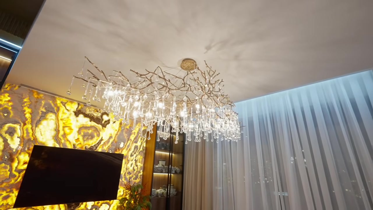 Formal living room with a chandelier and an onyx wall